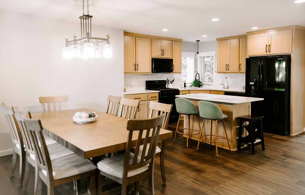A kitchen with a dining table and chairs in it.