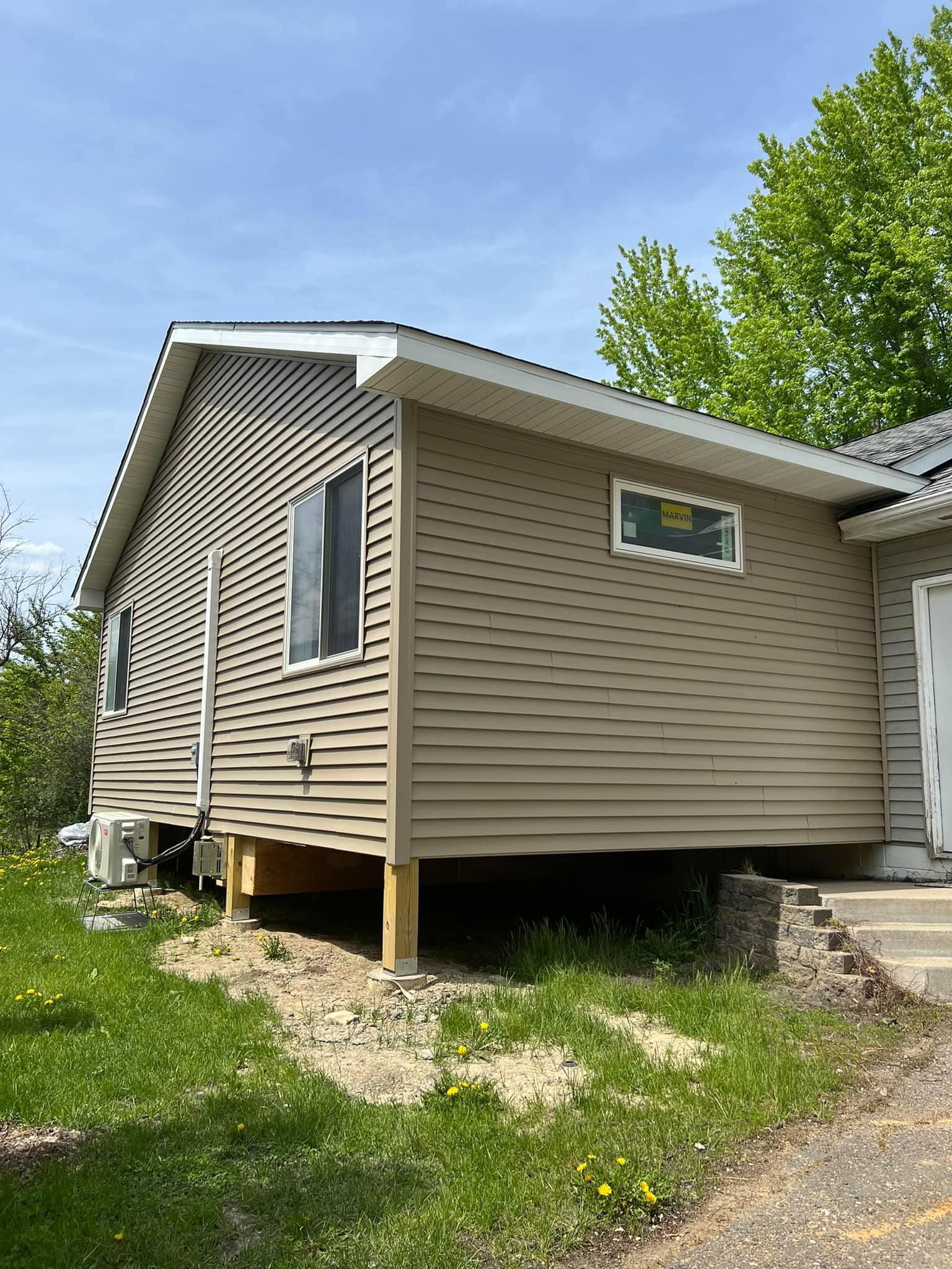 A small house is sitting on top of a grassy hill.