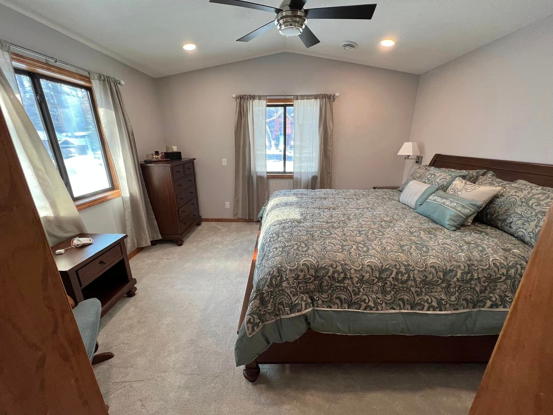 A bedroom with a king-size bed and a ceiling fan.