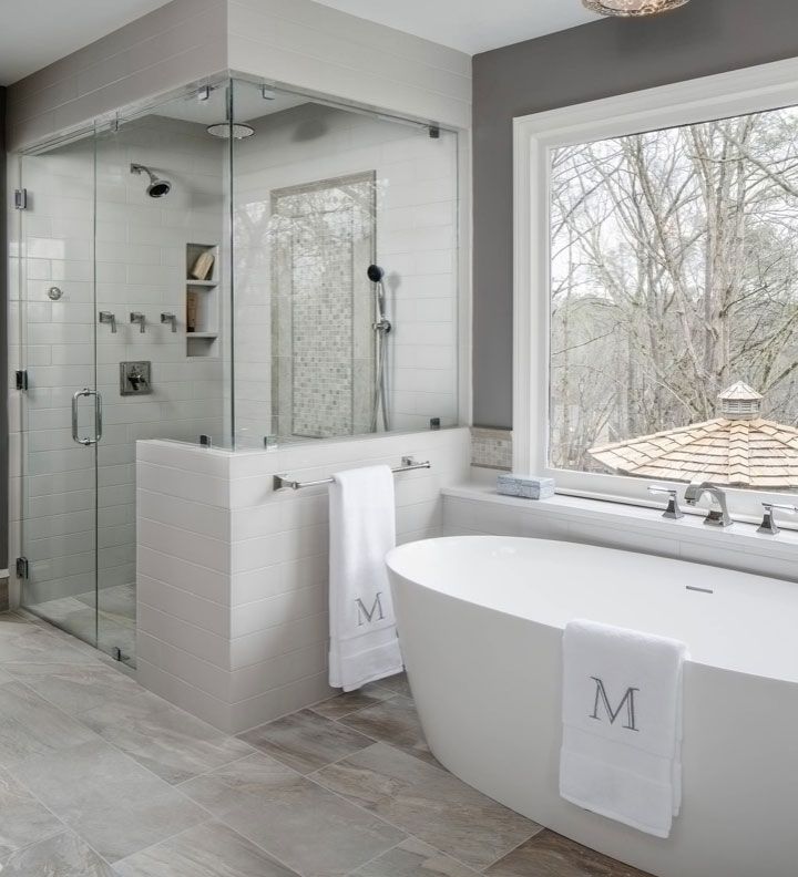 A bathroom with a tub , shower , and window