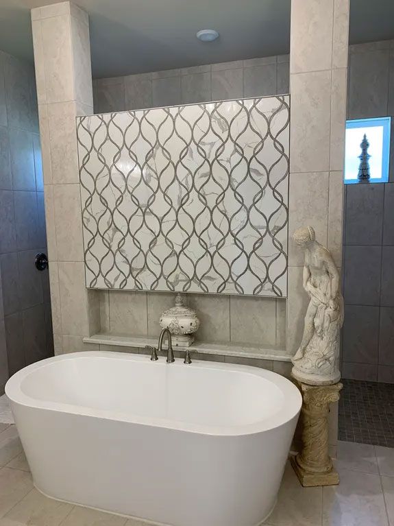 A bathtub is sitting in a bathroom next to a statue.