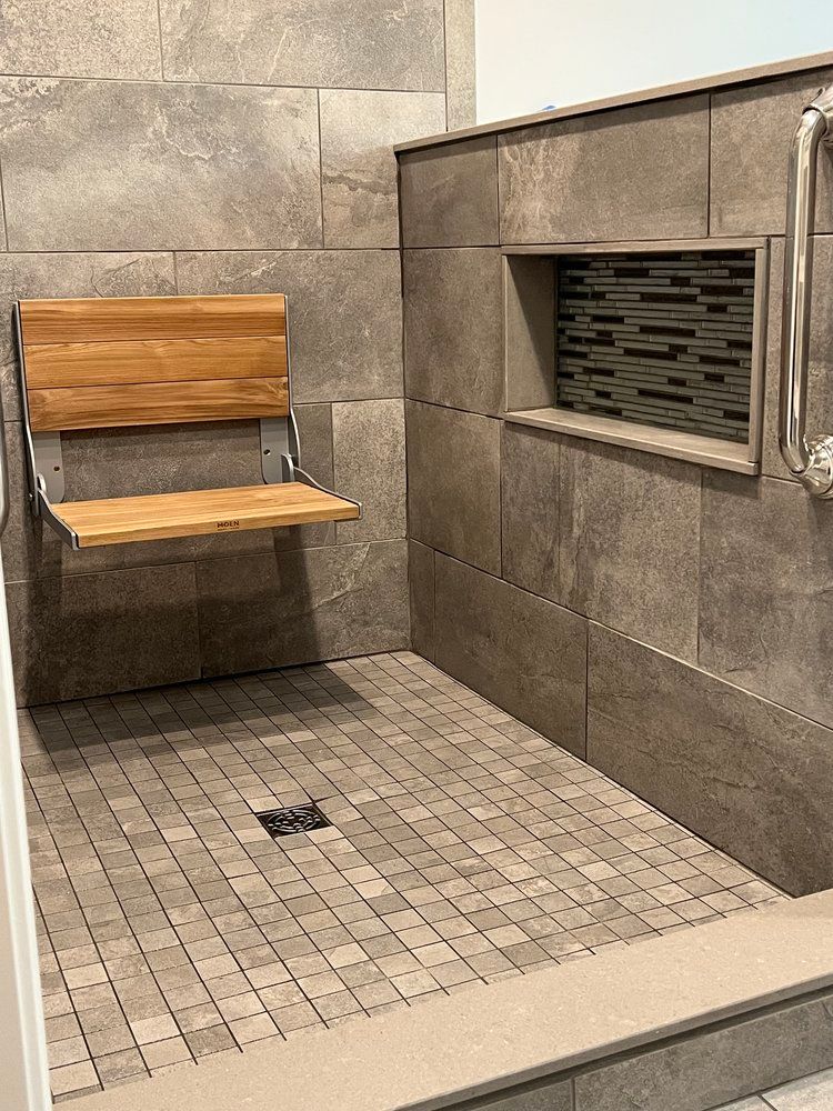 A shower with a wooden seat attached to the wall.