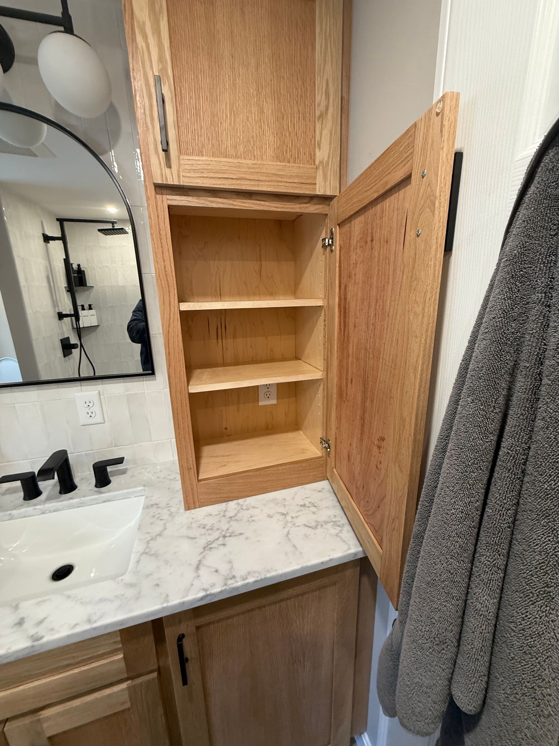 A bathroom with a sink and a cabinet with the door open.