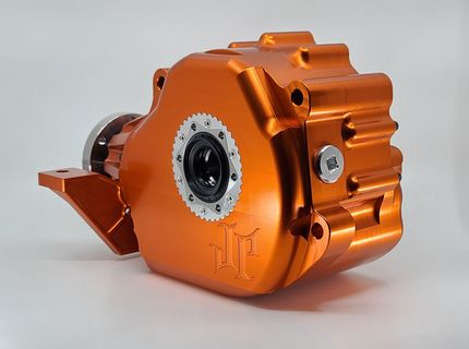 Orange metal mechanical part with a circular central opening on a white background
