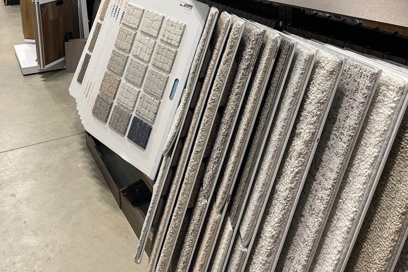 A bunch of carpets are stacked on top of each other in a store.