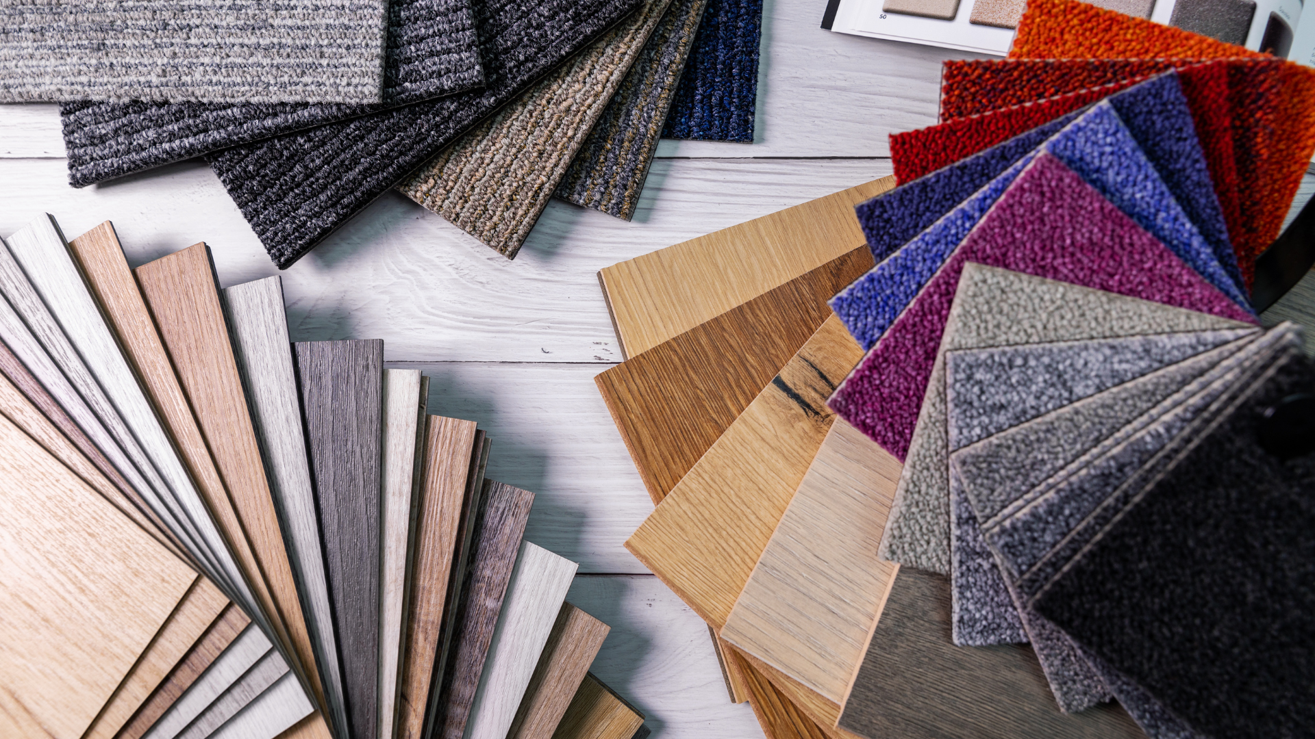 Samples of flooring and carpet textures in various colors, arranged on a white surface.