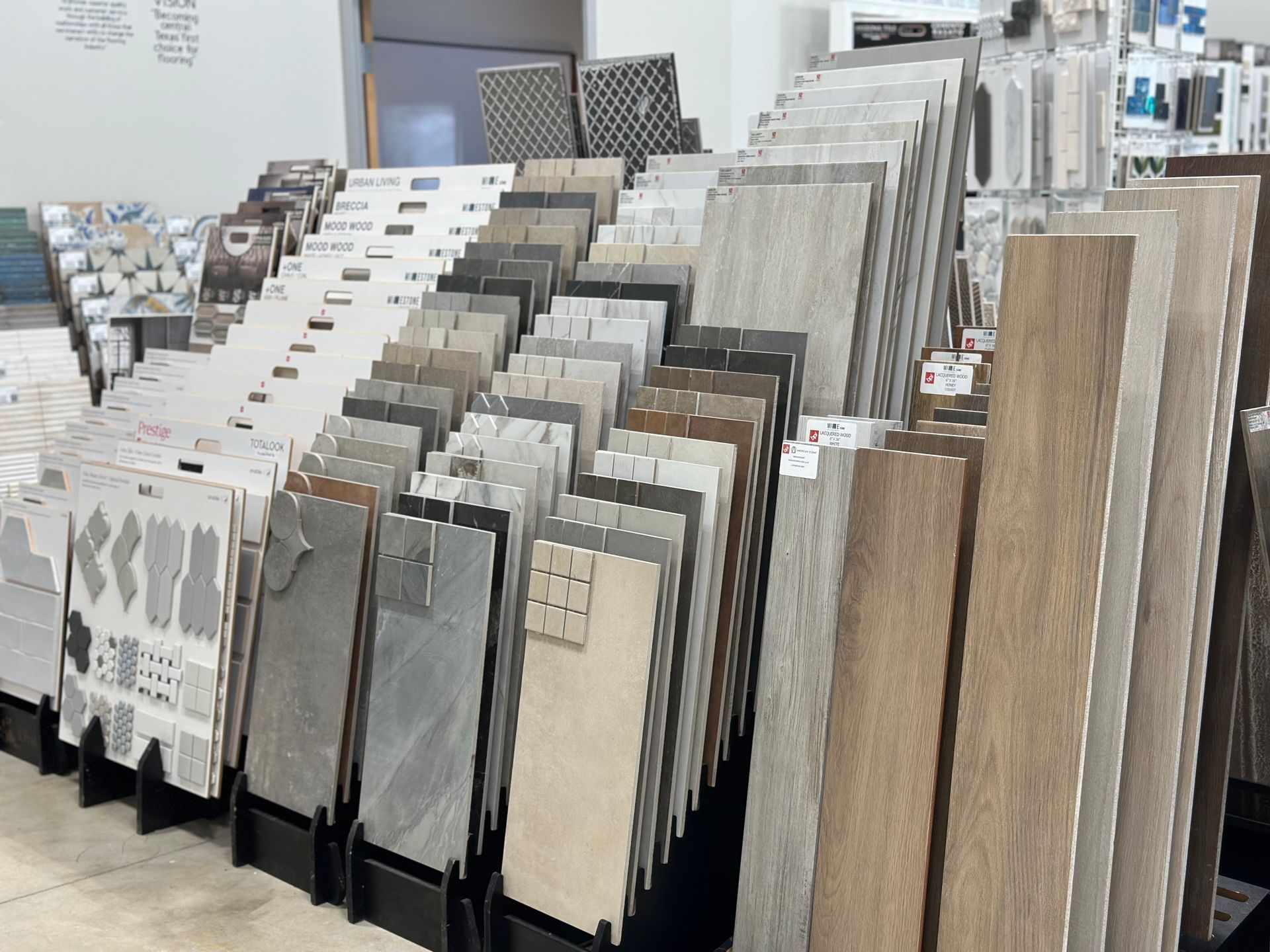 Tile display in a store, showcasing various tile patterns, colors, and textures, including wood-look tiles.