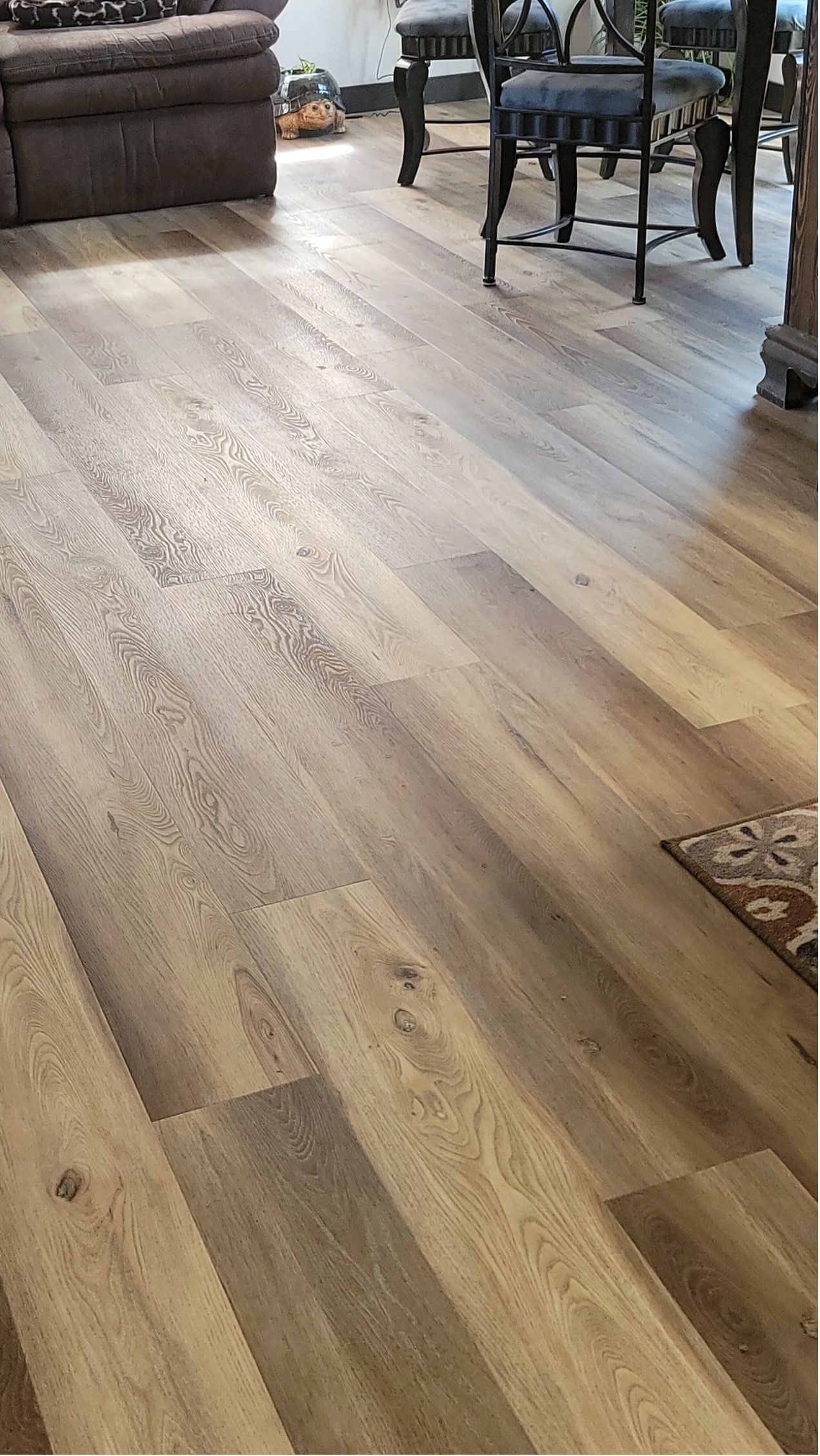 A living room with hardwood floors and a table and chairs.
