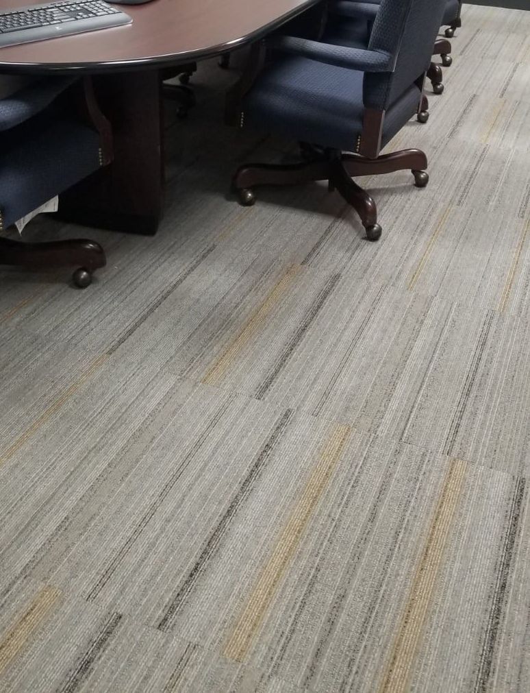 A conference room with a table and chairs and a carpeted floor.