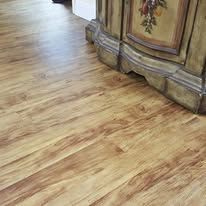 A close up of a wooden floor next to a cabinet.