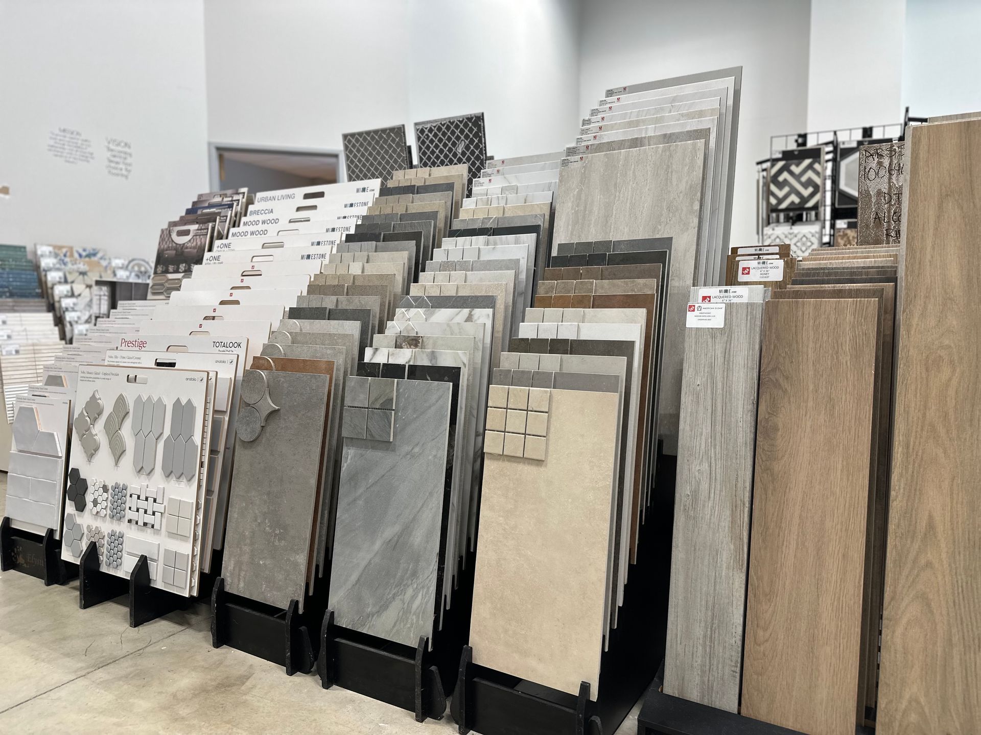 Tile samples displayed on racks in a showroom, various colors and textures.