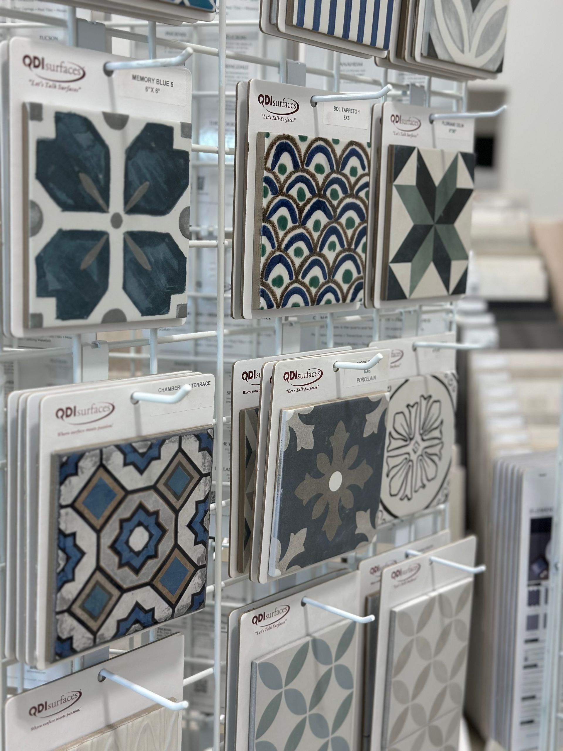 Display of patterned ceramic tile samples in various colors and designs.