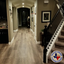 A hallway with stairs and a sign that says texas pride custom floors