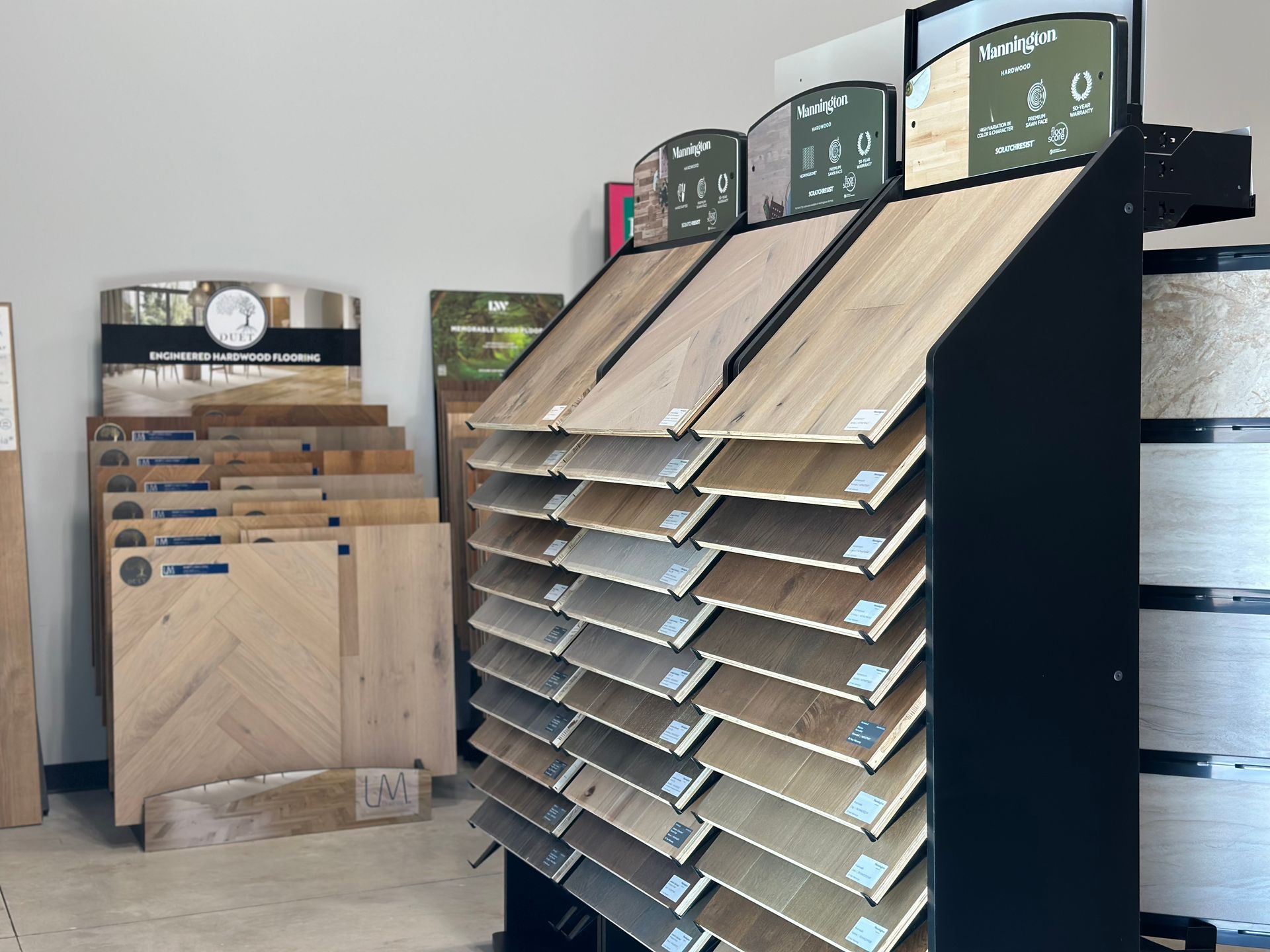 Flooring samples displayed in a retail setting, showcasing various wood tones and styles.
