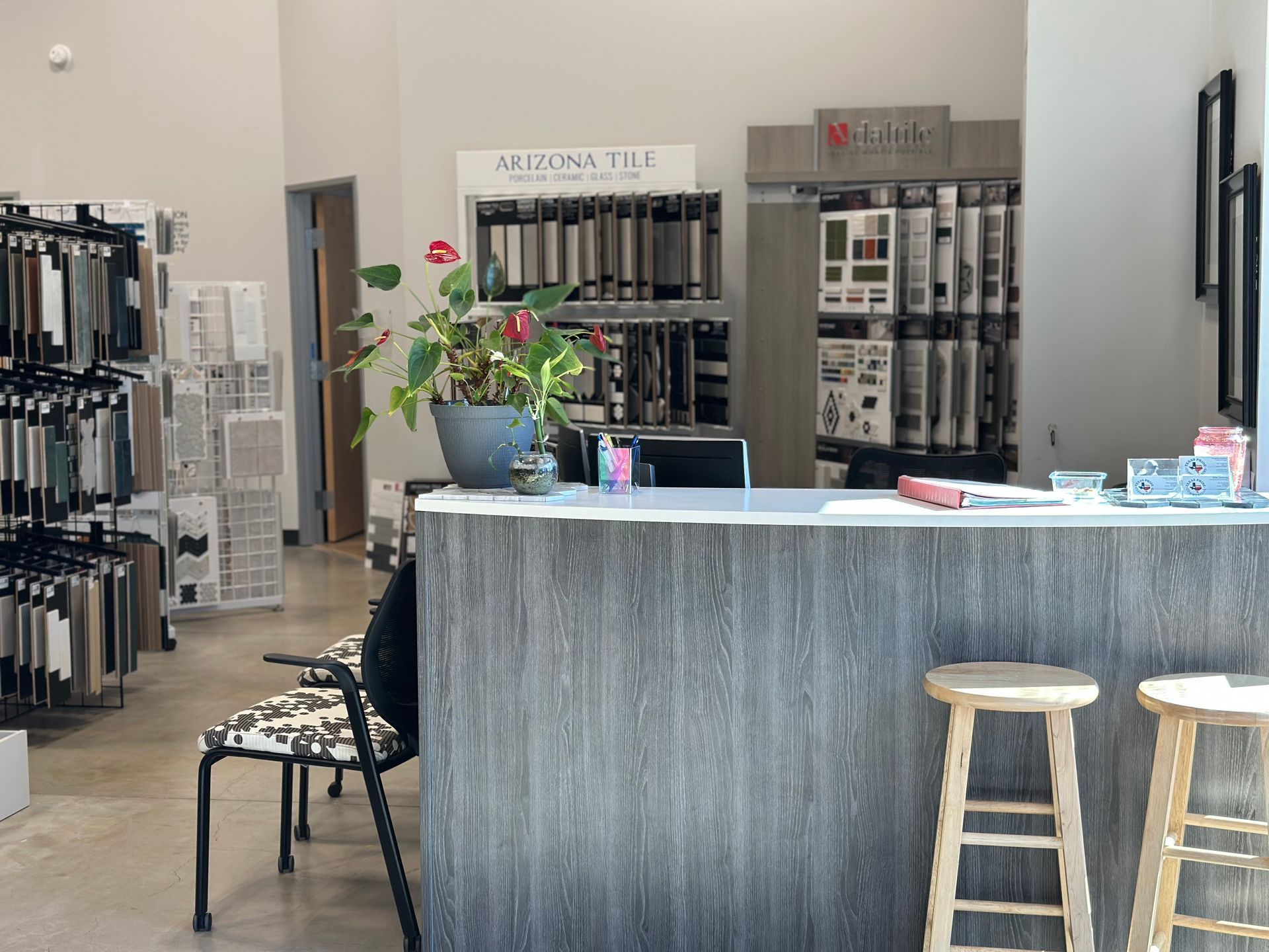 Reception desk in tile showroom with samples and stools.