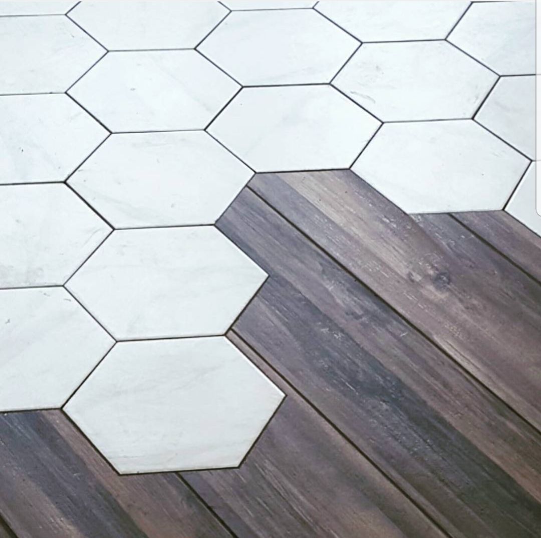 A wooden floor with white hexagon tiles on it.