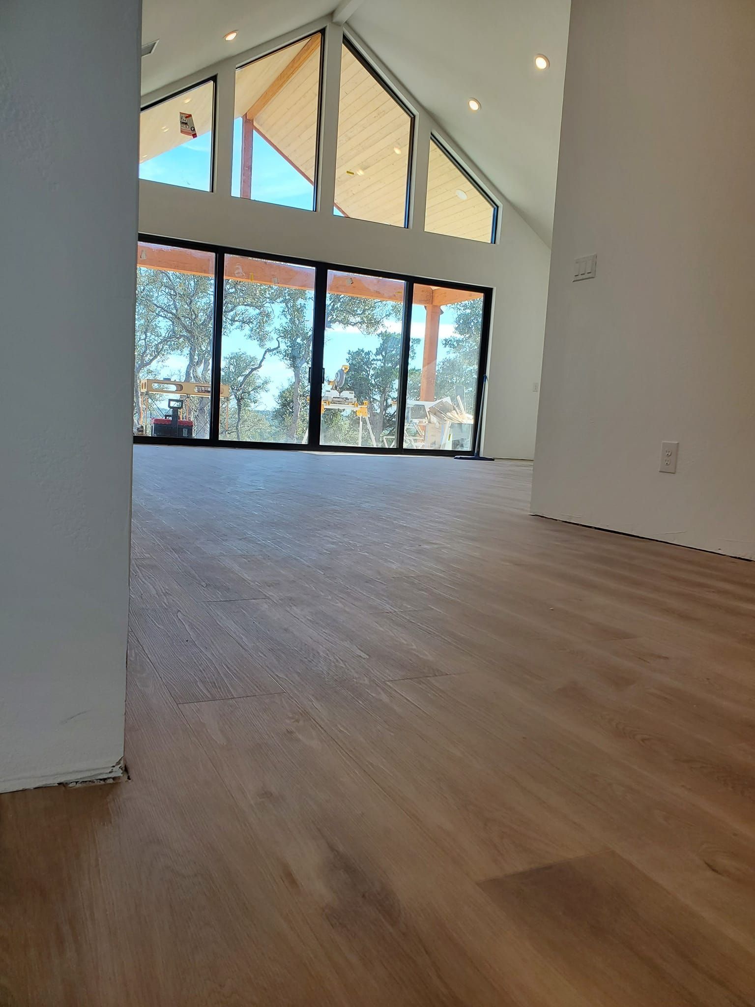 A large empty room with hardwood floors and lots of windows.