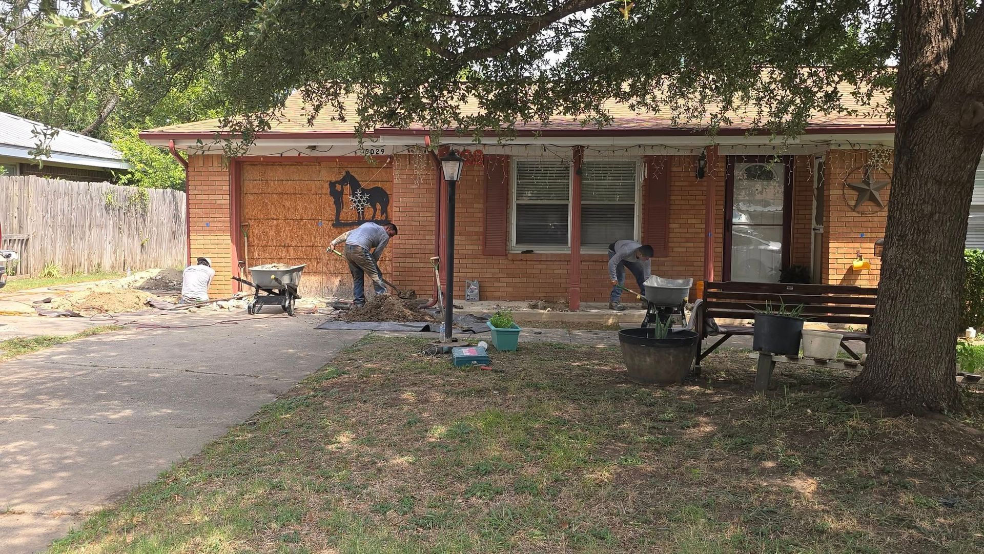 Two people working on the exterior of a house, possibly a renovation project.