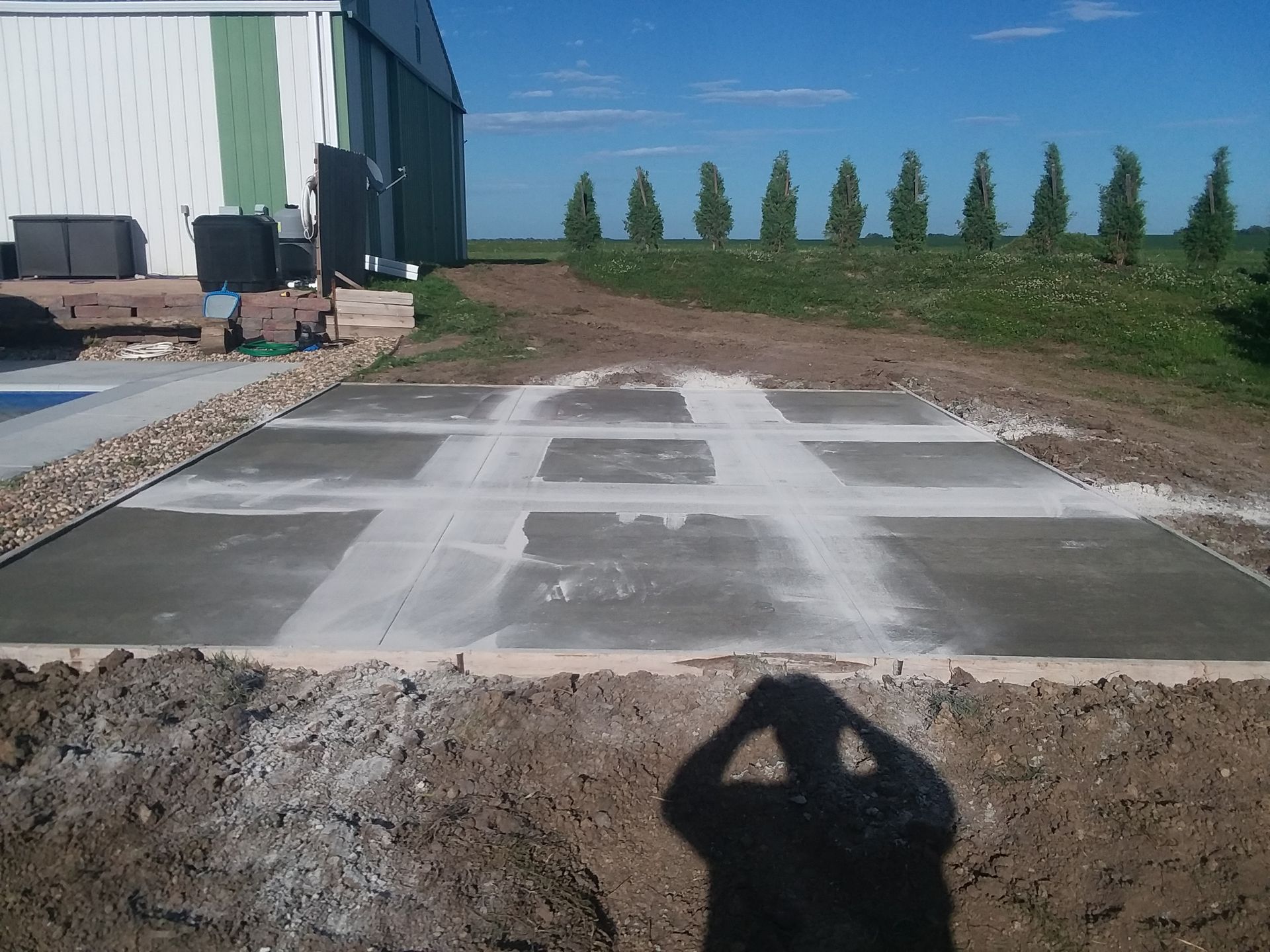 A shadow of a person is cast on the ground in front of a building
