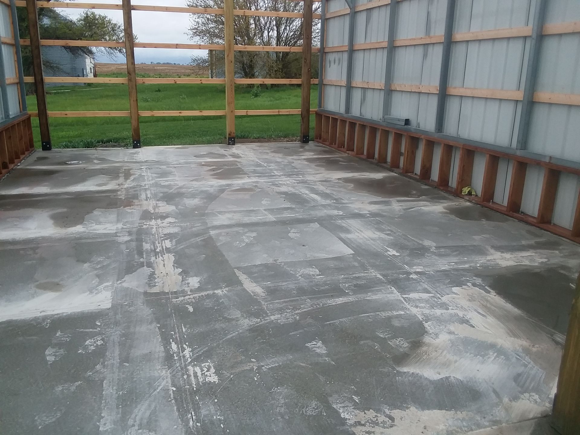 A concrete floor with a wooden fence in the background