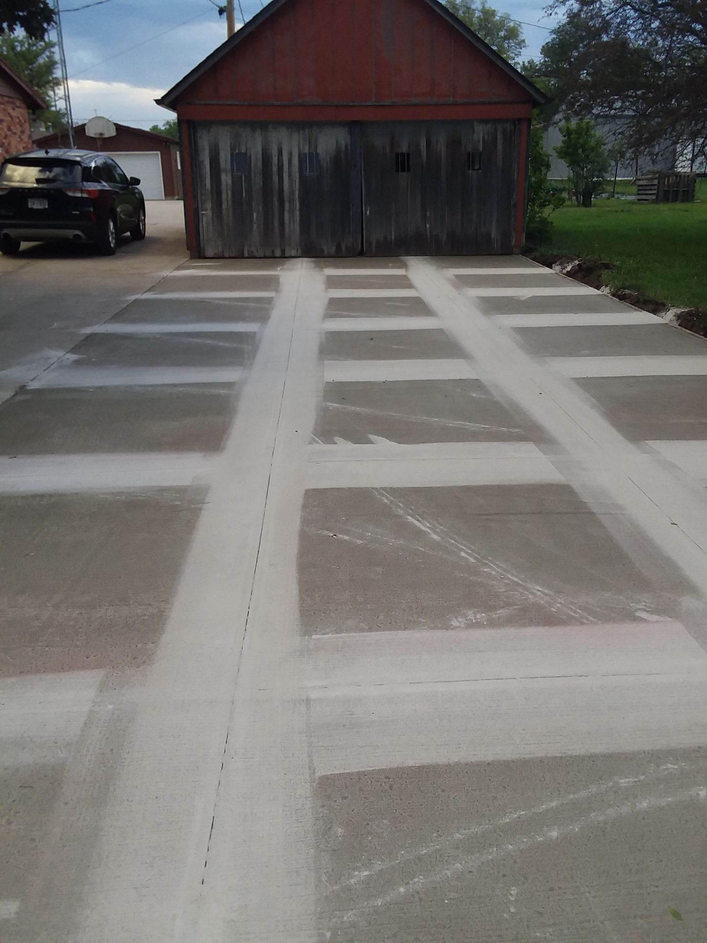 A car is parked in a driveway next to a garage