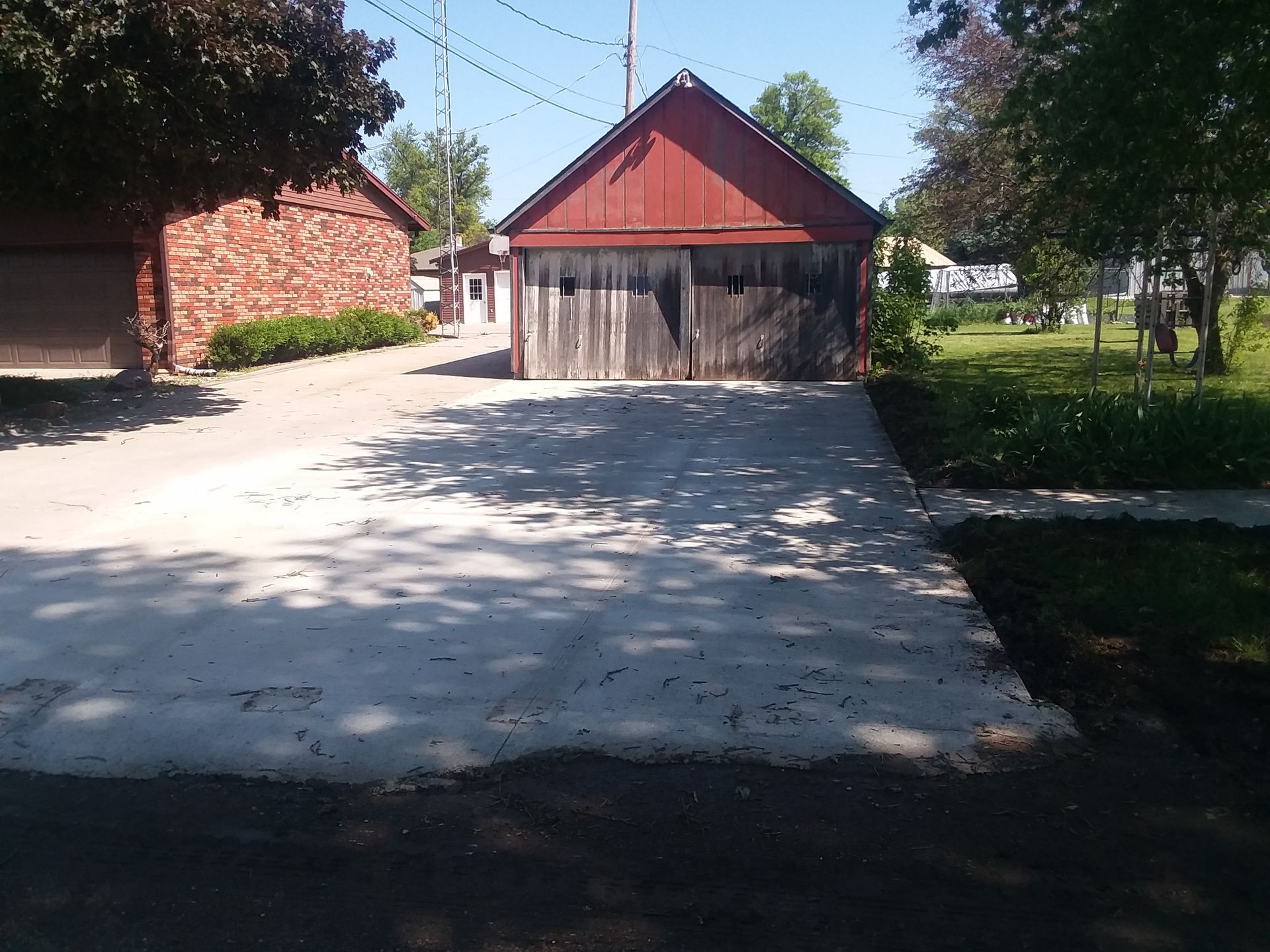 A driveway with a red barn in the background