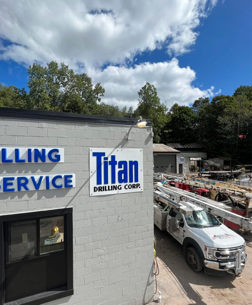 Titan Drilling Co. building with parked work trucks under a bright blue sky