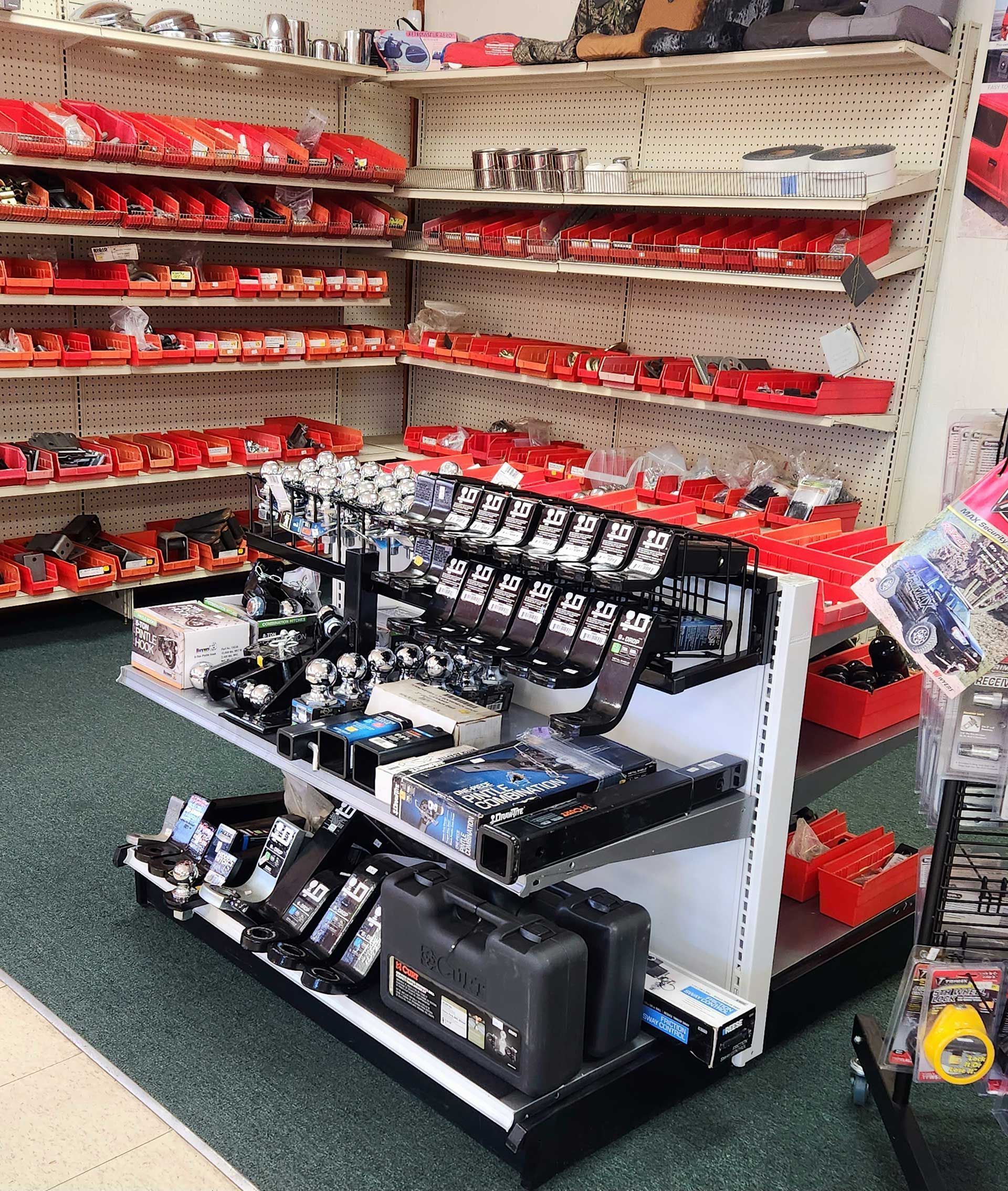 Store aisle with shelves of red and black merchandise displays and tools in the foreground