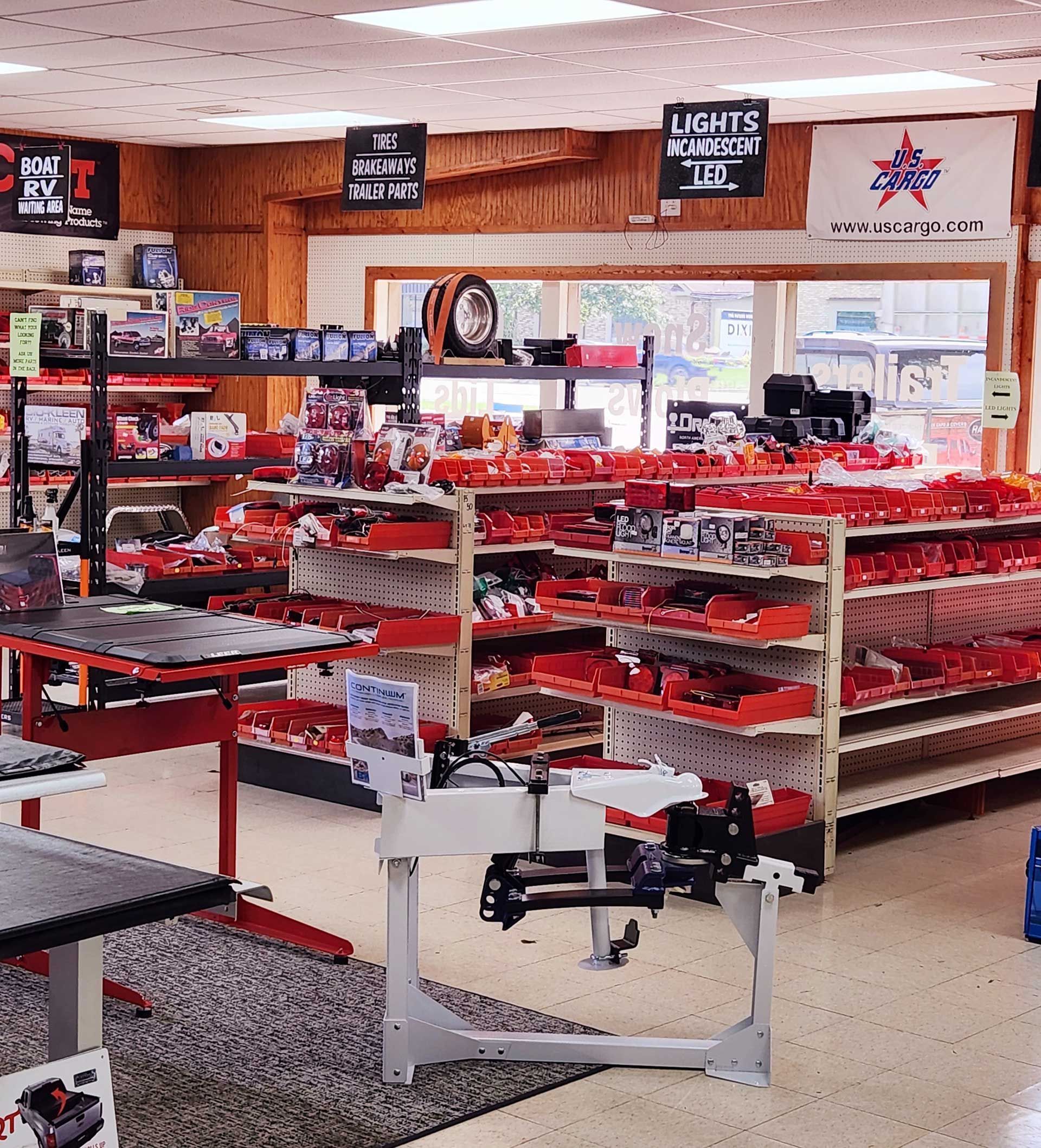 Indoor retail store with red merchandise displays and shelves under overhead signs.