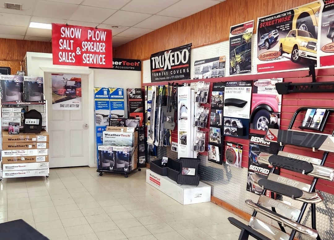Auto parts store interior with red walls, posters, shelves of accessories, and a service sign