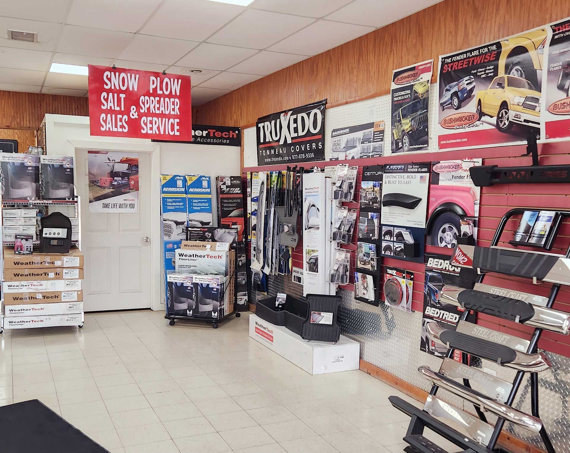 Car accessories shop interior with tire racks, posters, and display shelves against wood-paneled walls