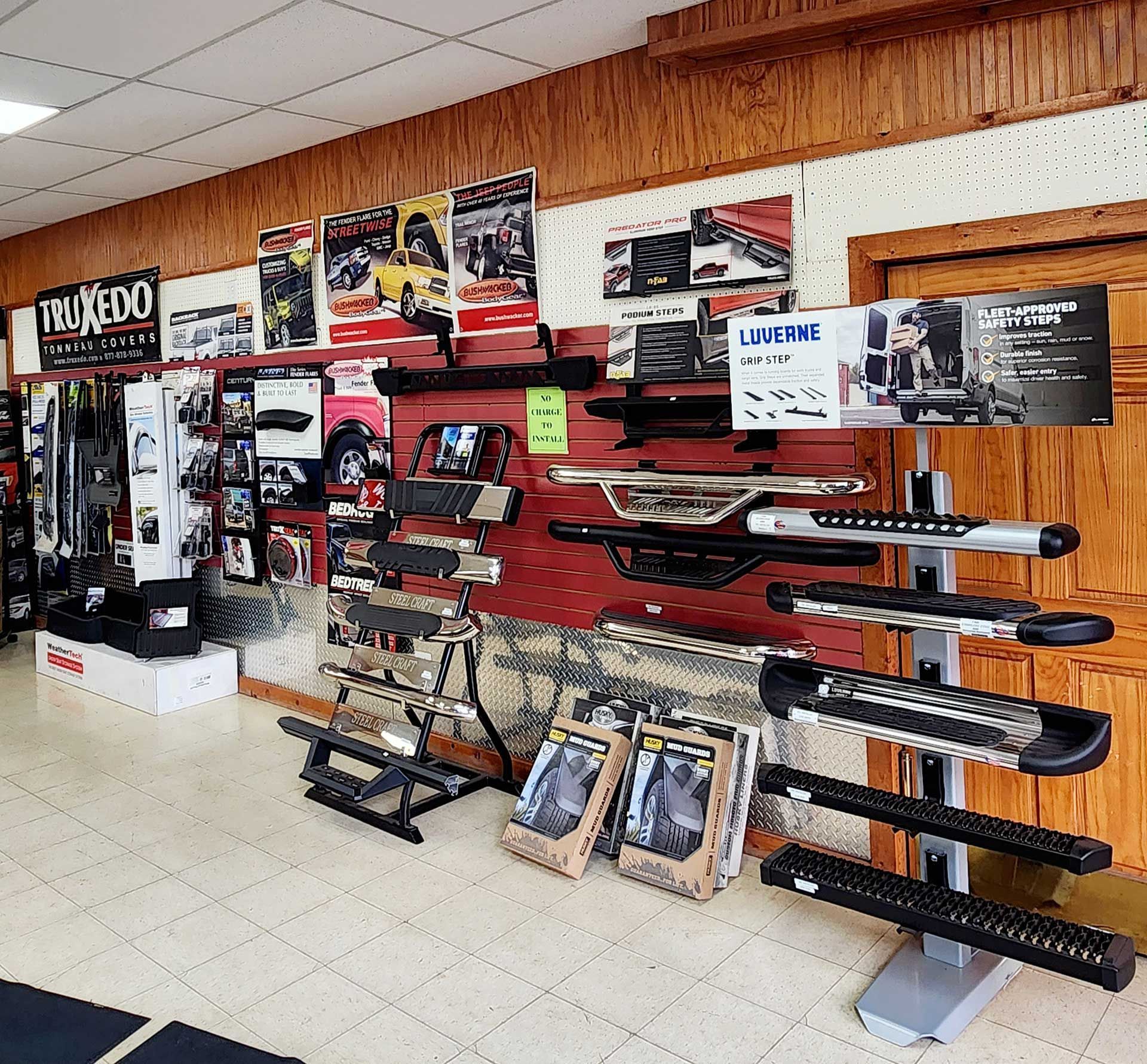 Gun store interior with rifles displayed on wall racks and glass counters under wood-paneled ceiling