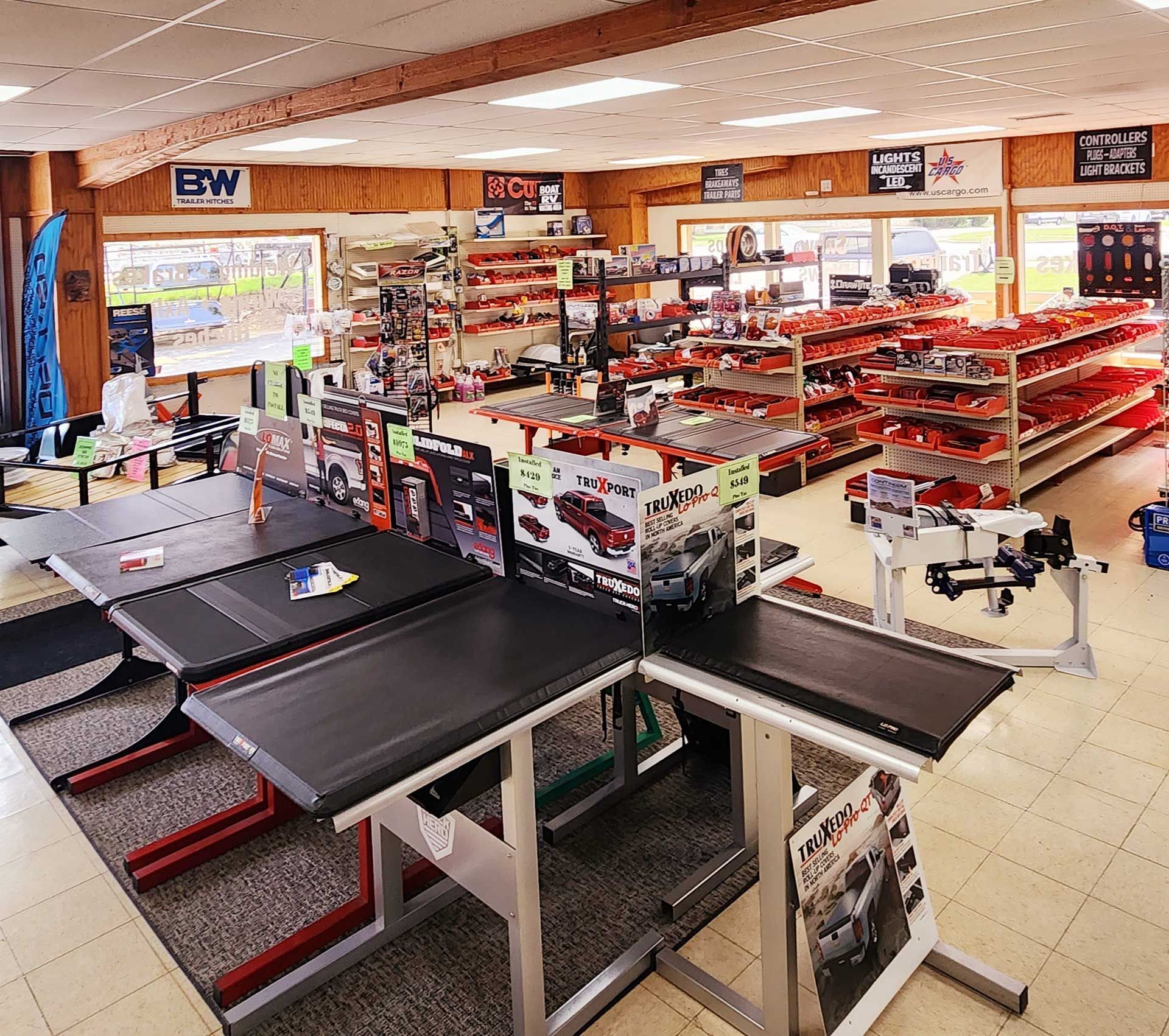 Pet store interior with rows of fish tanks, shelves of pet supplies, and grooming tables in the foreground