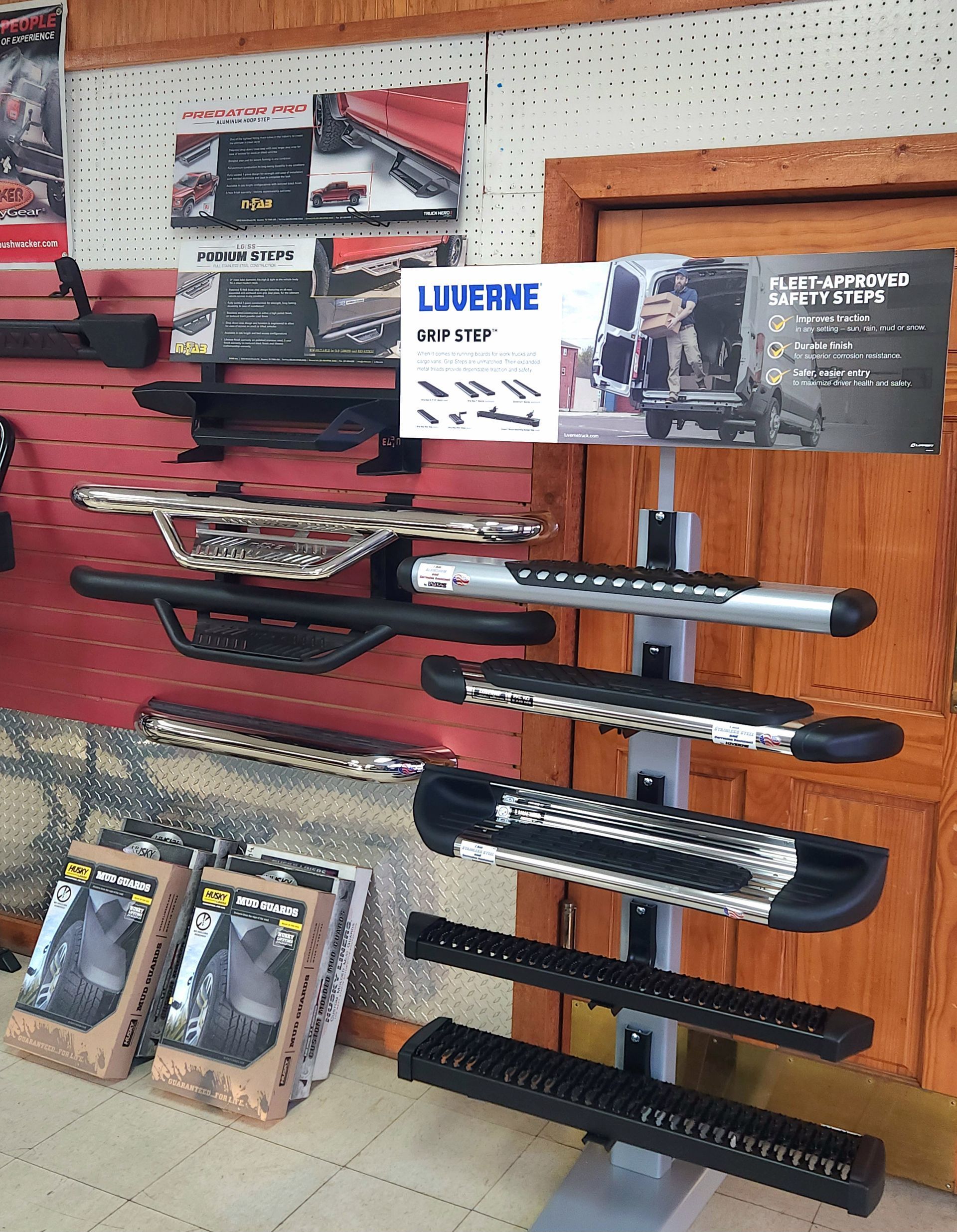 Display of tactical-style knives and sheaths on a store wall, with an 
