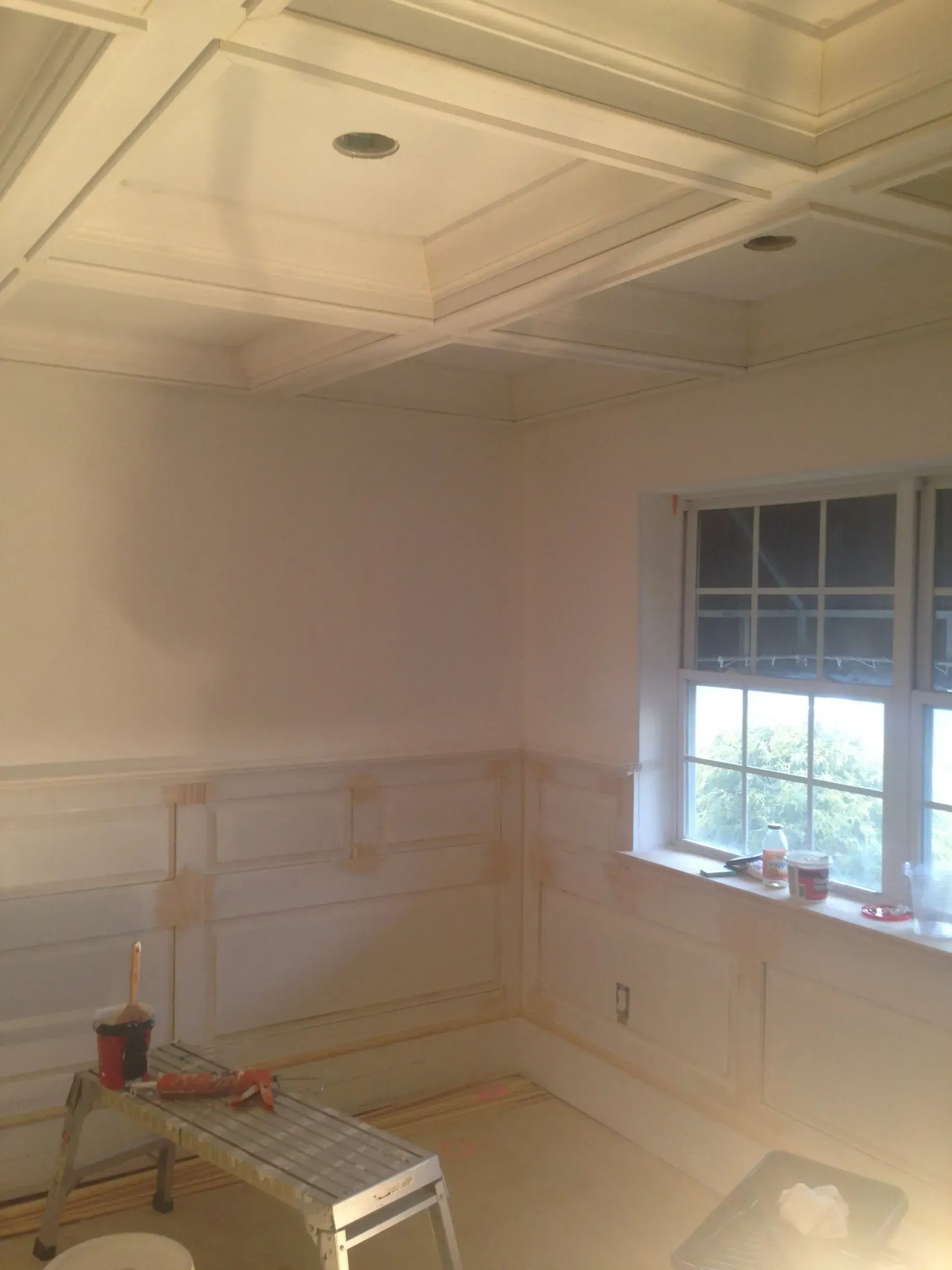 Small empty room with white walls, a window, and unfinished countertop work near the corner.
