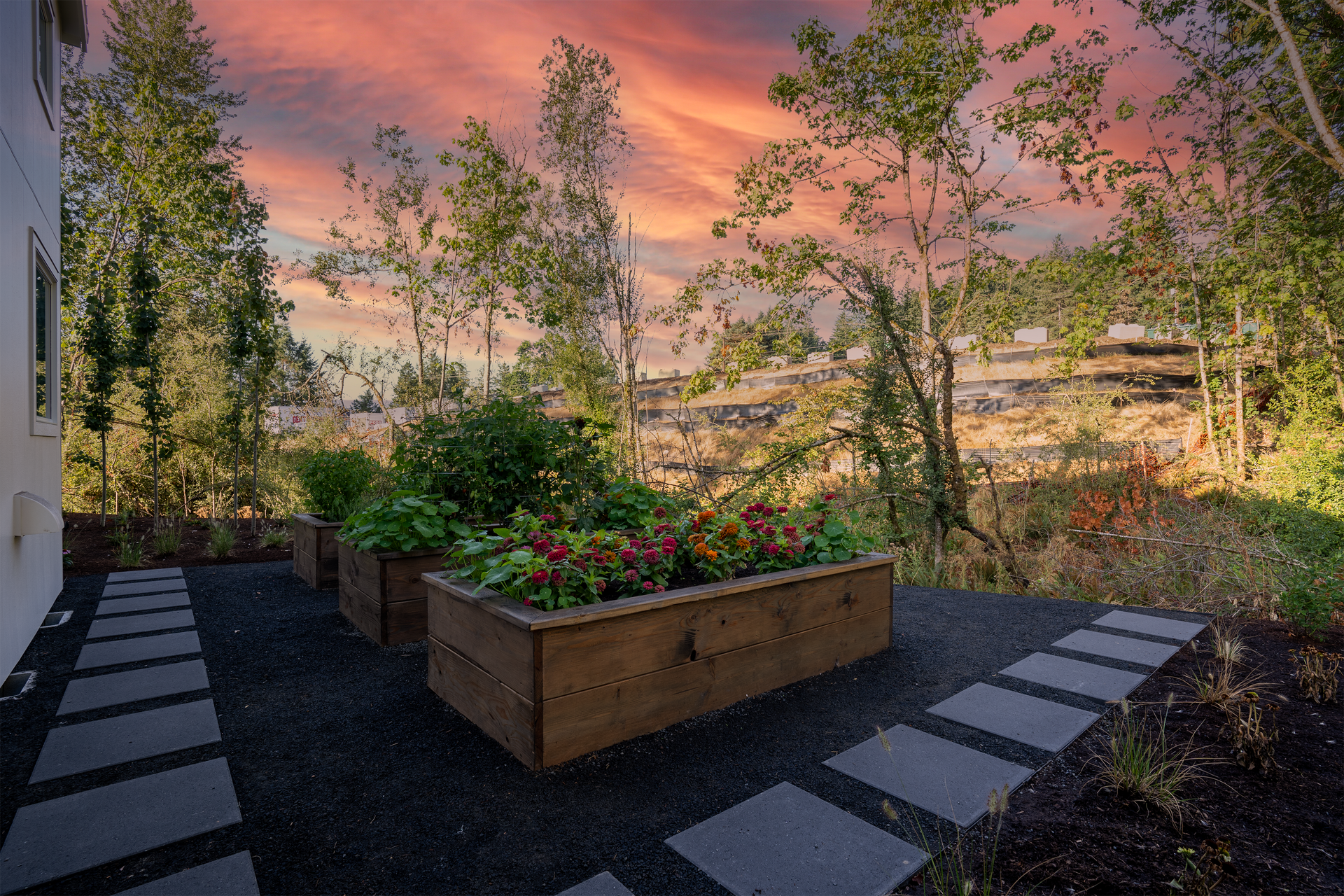 A patio with a wooden planter filled with flowers and trees.