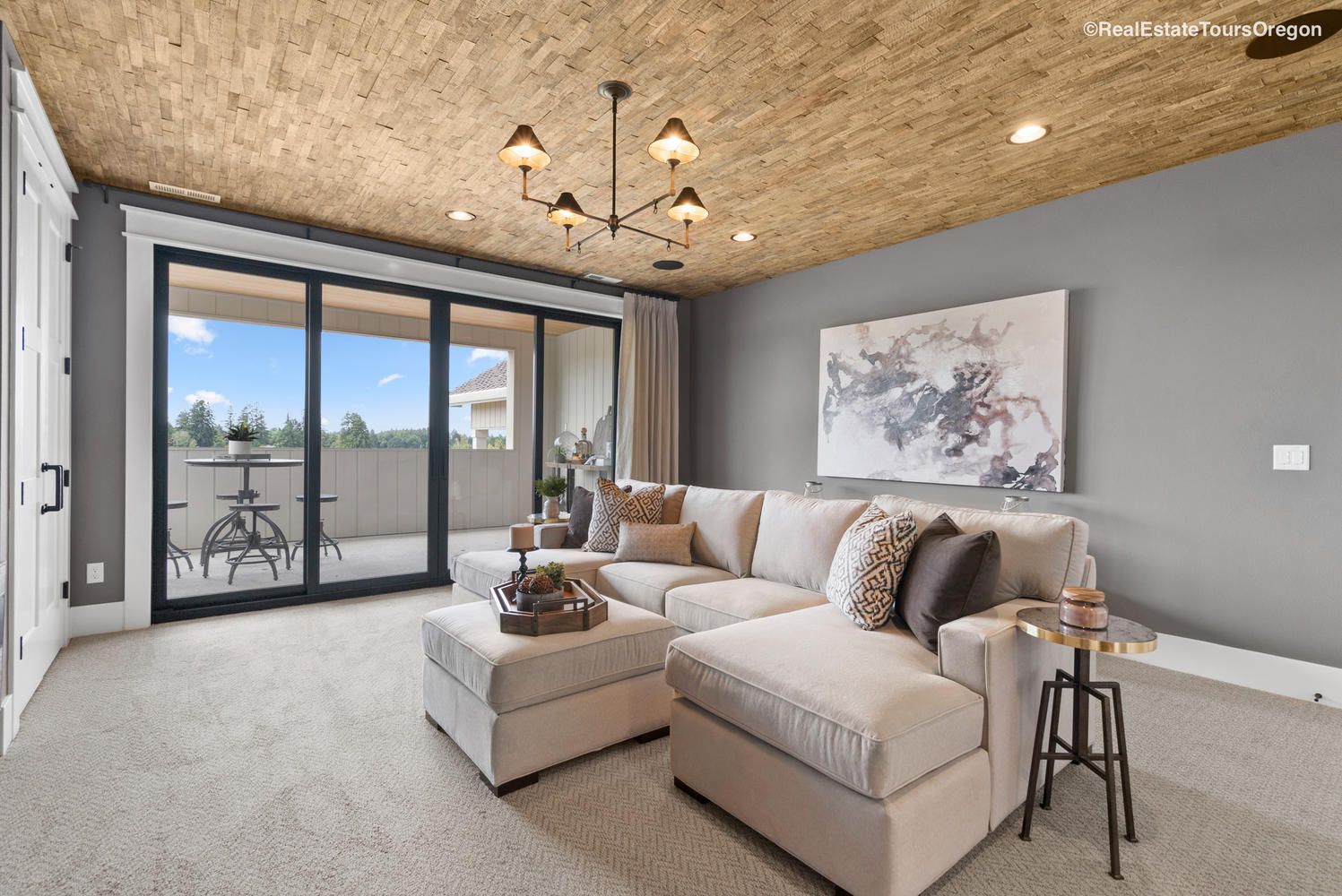 A living room with a couch , ottoman , table and sliding glass doors.