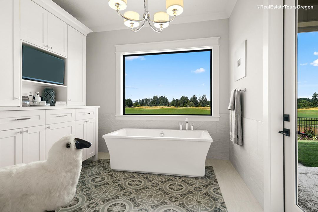 A bathroom with a tub and a window with a view of a golf course.