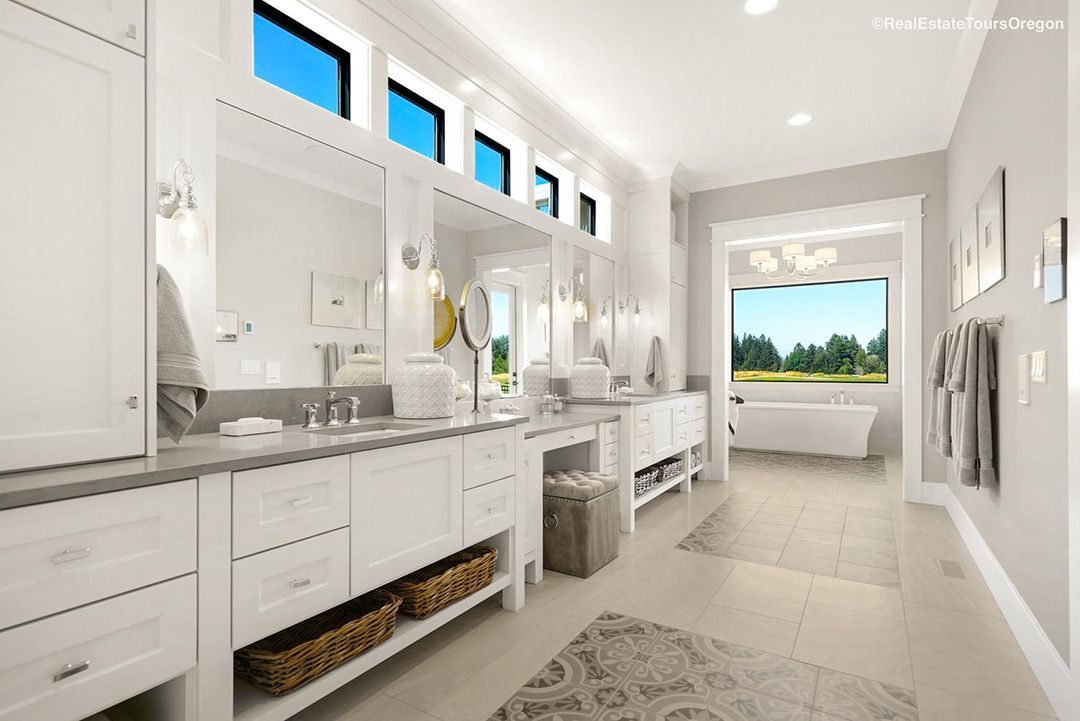 A bathroom with two sinks , a tub and a window.