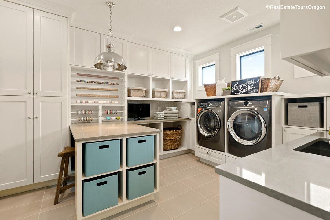 A laundry room with a washer and dryer and a counter top.