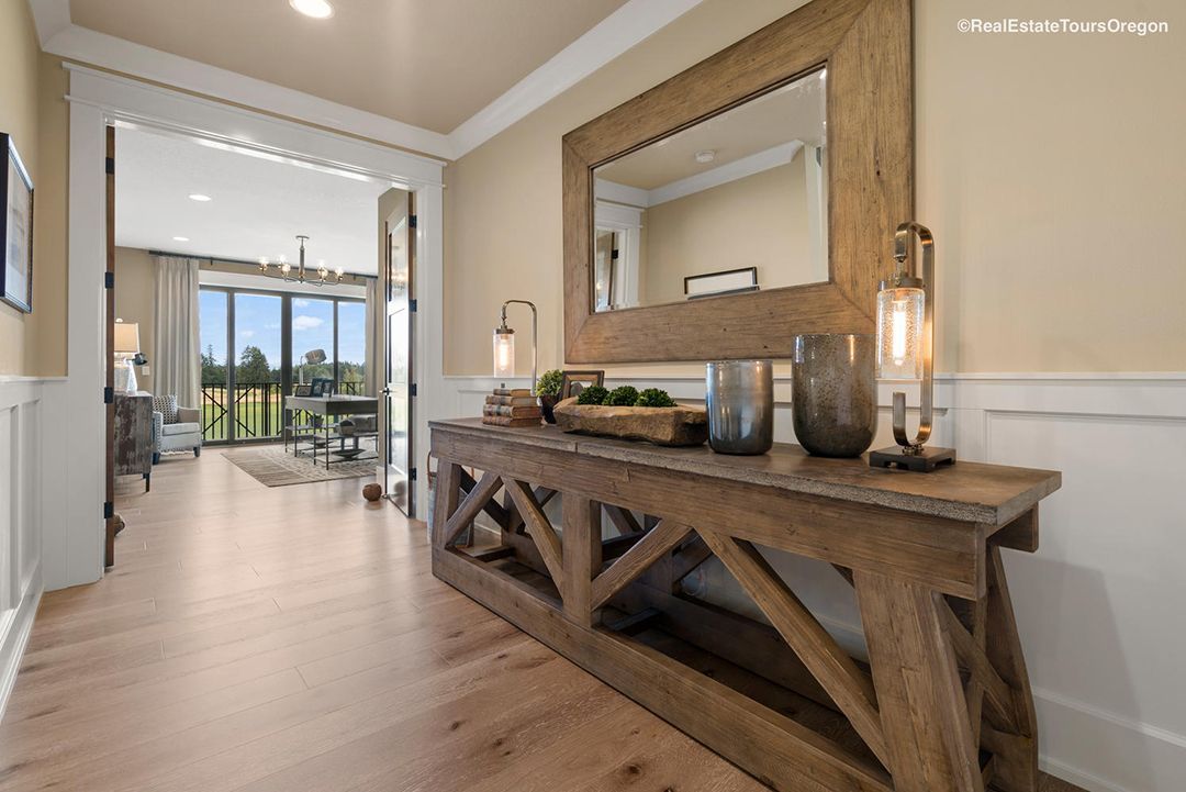 A wooden table with a mirror on top of it in a hallway.