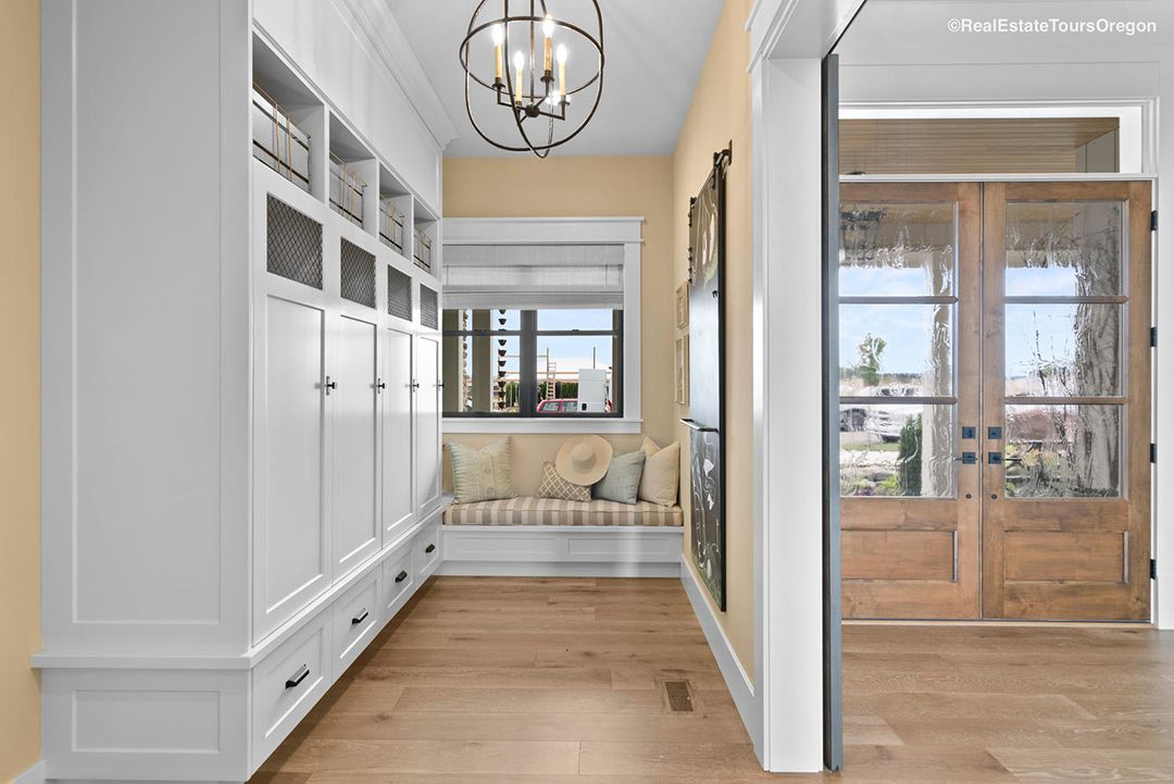 A hallway with a bench in the middle of it and a chandelier hanging from the ceiling.