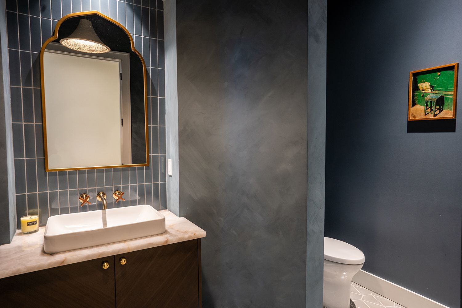 A bathroom with a sink , mirror and toilet.