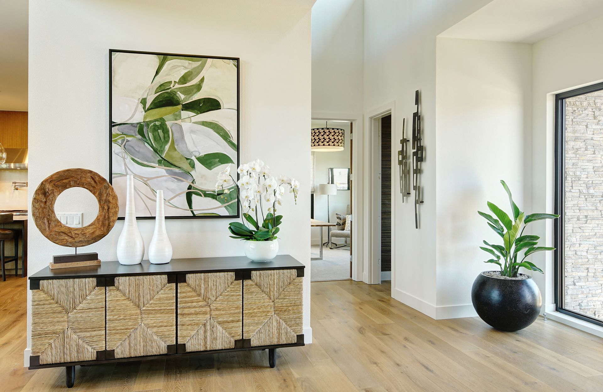 There is a painting on the wall above the dresser in the hallway.