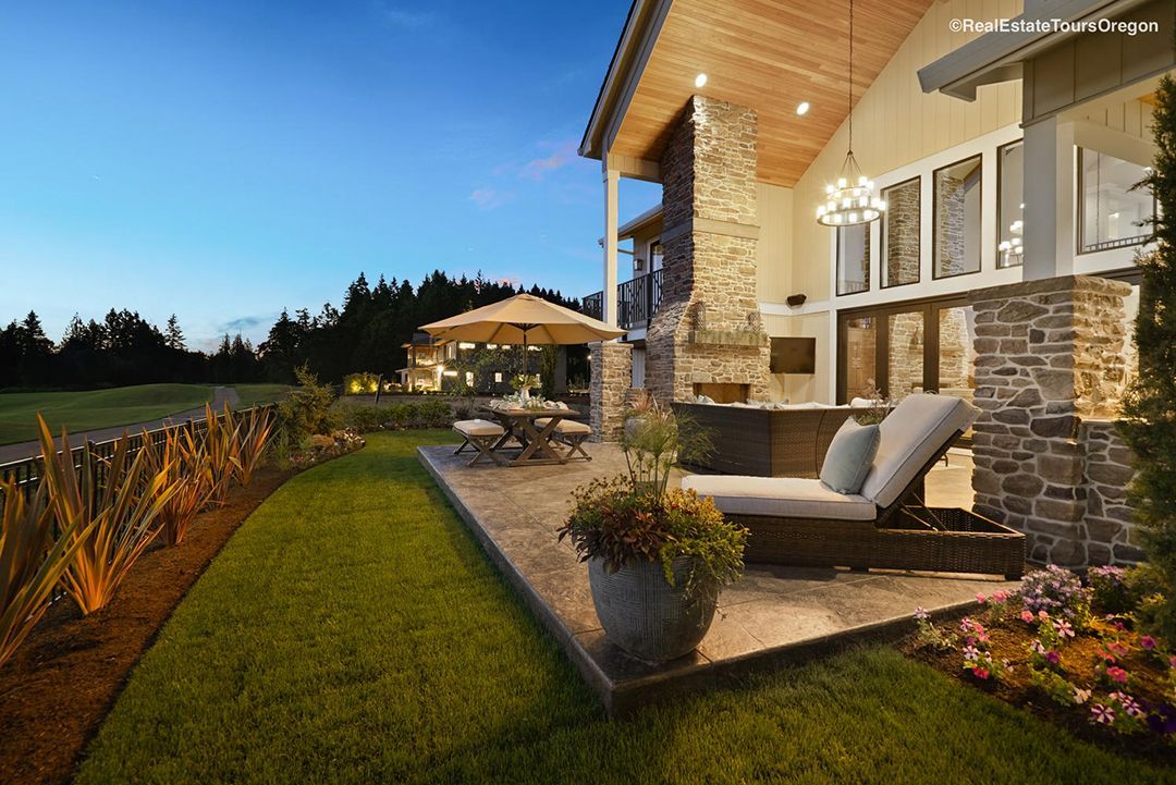 A large house with a patio and chairs in front of it.