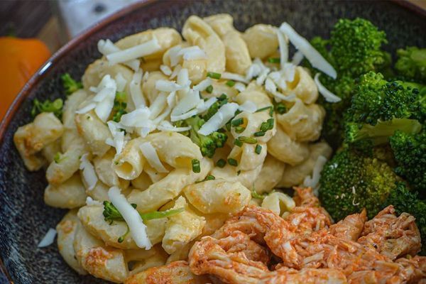 Macaroni and cheese with broccoli and chicken in a bowl.