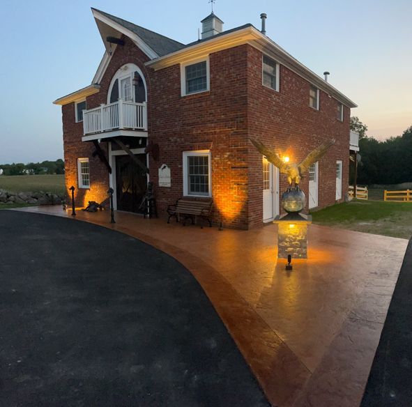 Brick building with lit up walkway, eagle statue, and balcony.