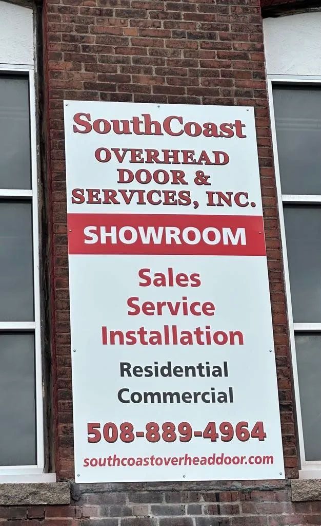 Sign for SouthCoast Overhead Door & Services, Inc., with showroom info, services, and phone number.