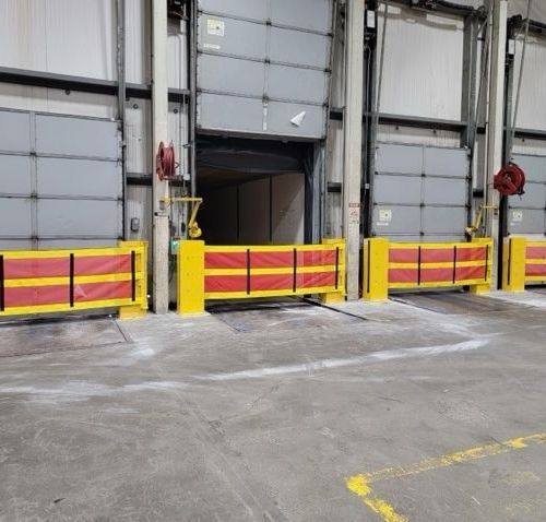 Dock doors with yellow and red safety barriers in a warehouse setting.