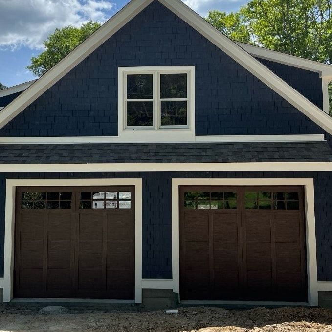 Blue house with brown garage doors and white trim.